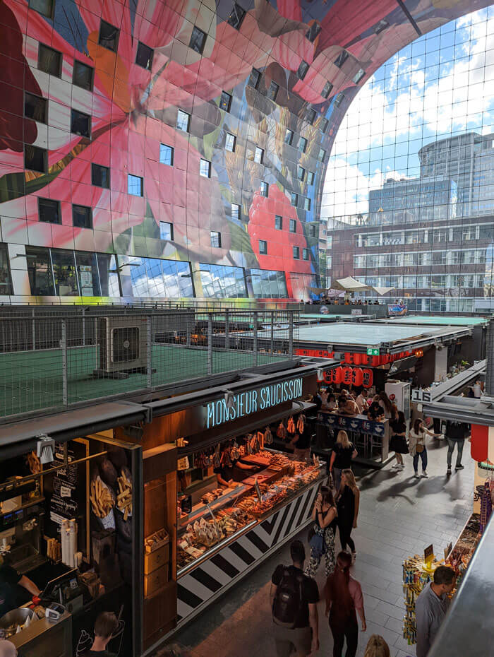 Some of the stalls inside Markthal. The windows set into the mural belong to the apartments that cover the roof.