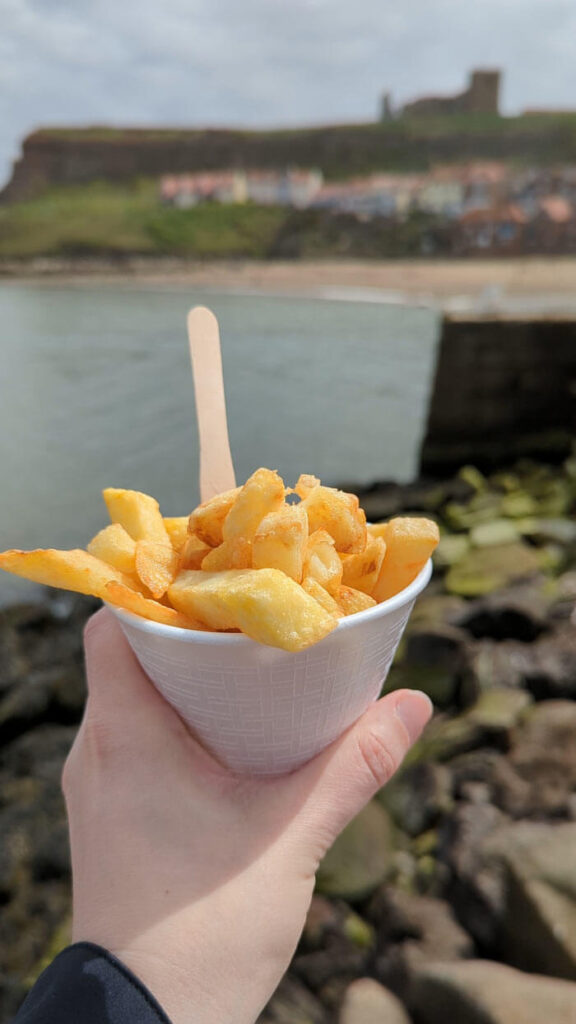 Eating chips on the harbour wall, one of the best things to do in Whitby