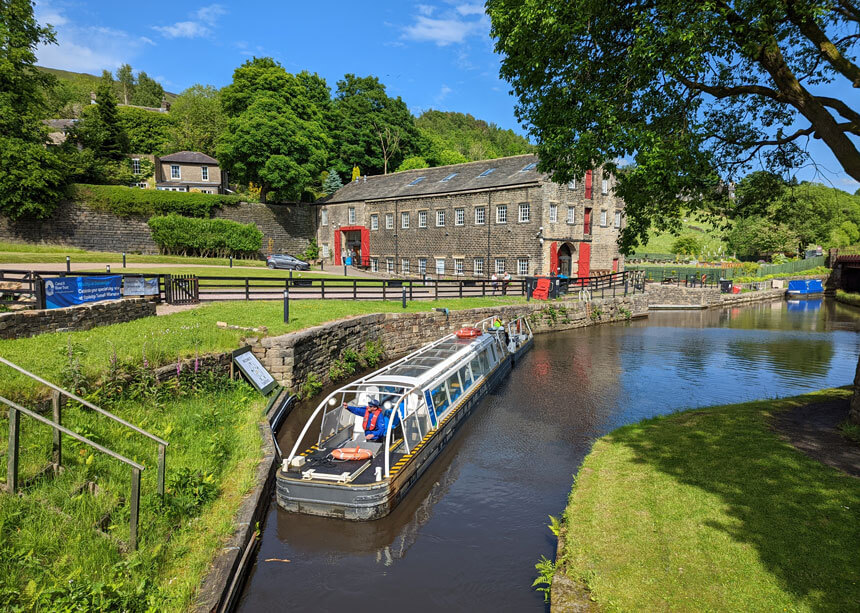 One of the canal tour boats by the old canal warehouse, now the Standedge Tunnel Visitor Centre