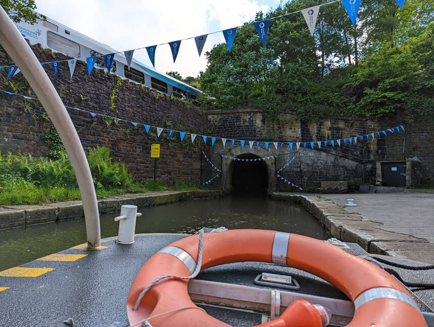 Our boat trip into the Standedge canal tunnel about to set off. You can see a train on the top right about to enter the railway tunnel.