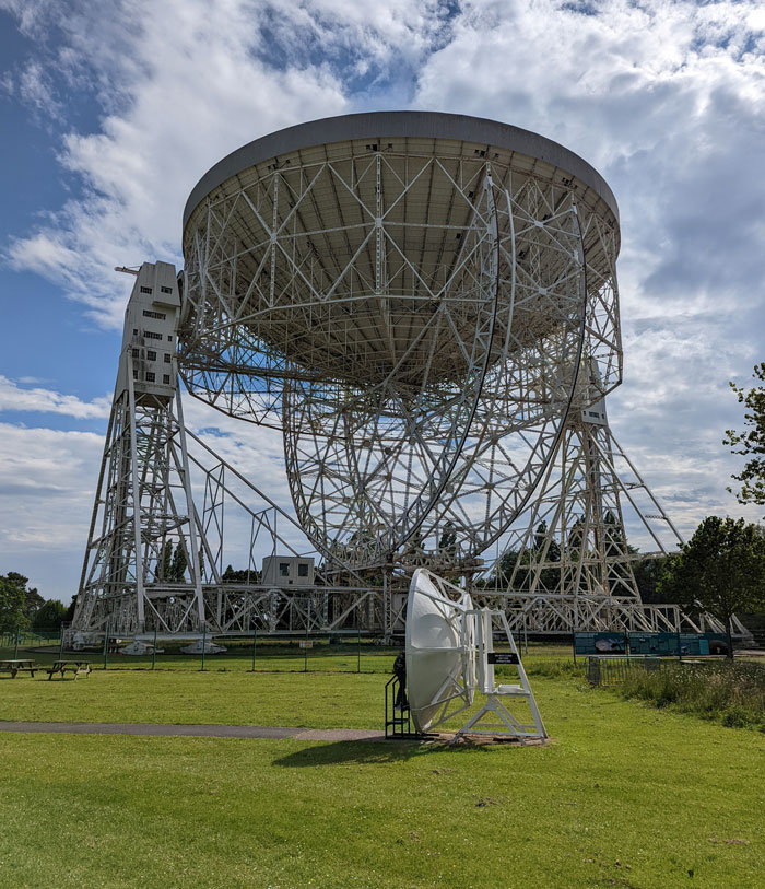 One of the pair of Whispering Dishes in the shadow of Jodrell Bank's radio telescope