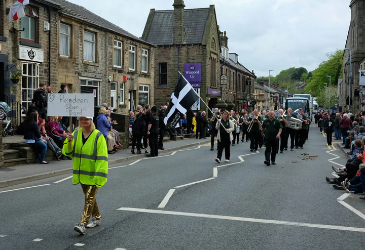 A band marching through Uppermill on Whit Friday. You can see the coaches that carry the bands around the villages in the background. Each village can see between 40 and 70 bands in just one night.