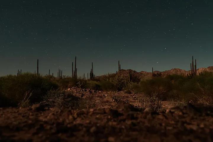 The night sky in Bahia De Los Angeles, Baja California. A desert foreground with a sky full of stars.