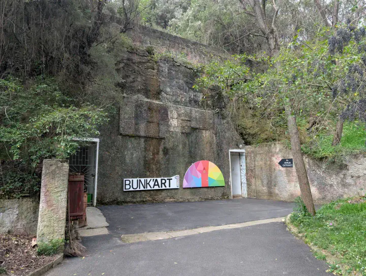 The entrance to Bunk'Art 1 in Tirana is a little door in a cliff under a mountain on the edge of Tirana. But is Bunk'Art 1 or Bunk'Art 2 better? And should you visit both?