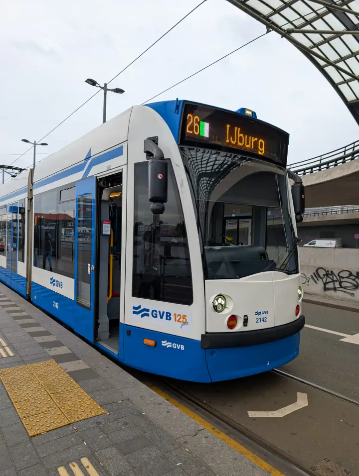 A blue and white Amsterdam tram outside Centraal Station