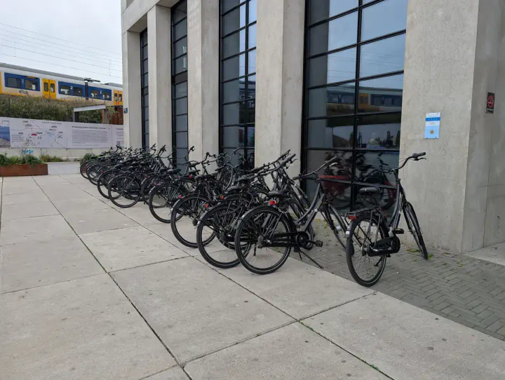 A row of black bikes for rent outside the Inntel Hotels Amsterdam Landmark hotel