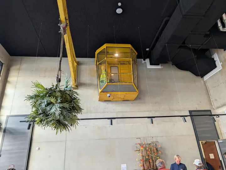 A hotel reception desk in the industrial-themed Landmark hotel. A yellow crane cab is suspended from the wall behind the reception desk.