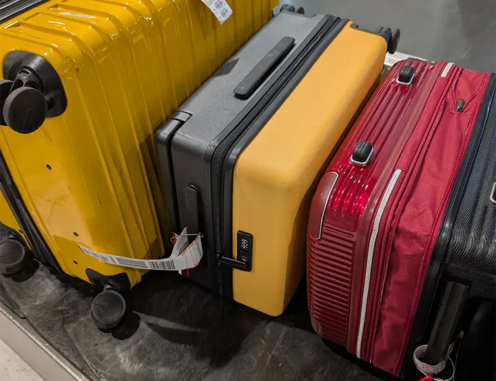 A yellow suitcase on an airport luggage belt
