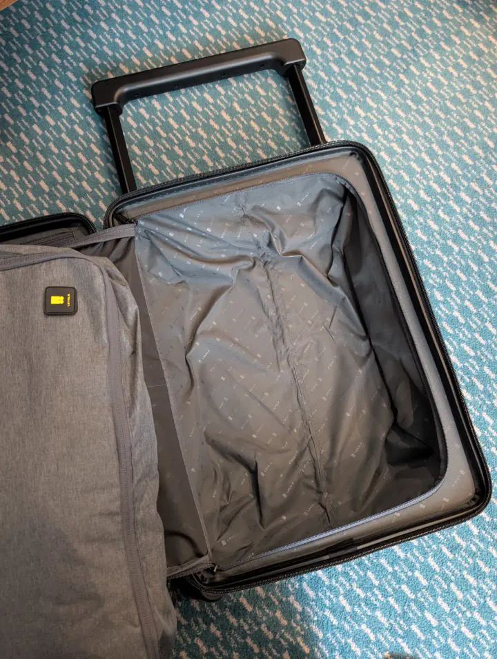 Inside a suitcase, showing that there are no bumps for the trolley handle down the middle of the rear compartment