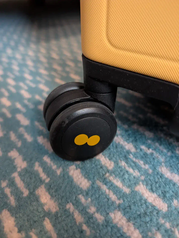 A suitcase wheel on a patterned carpet