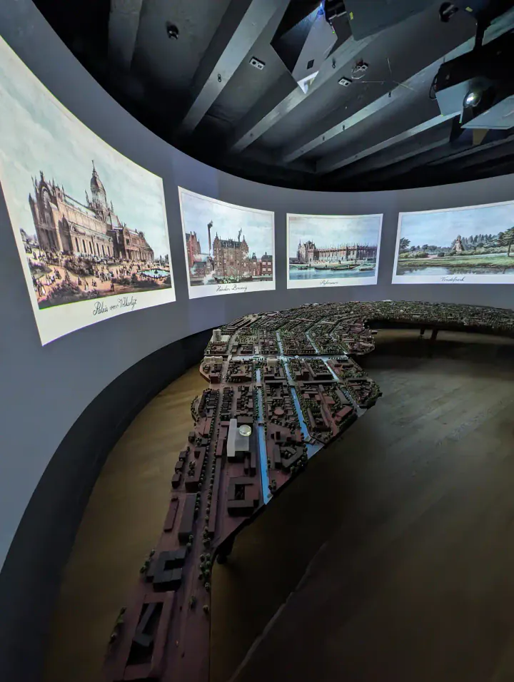 A multimedia display in the Museum of the Canals. A video is playing on a curved wall, and there's a detailed model of Amsterdam's historic canal ring to look at.