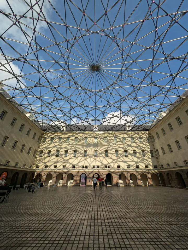 Inside the National Maritime Museum's historic courtyard. A modern glass roof is making patterns on the walls.