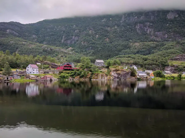 A small village with wooden houses by the side of a lake