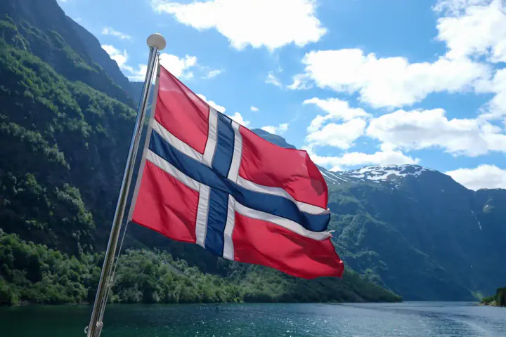 A Norwegian flag blowing in the wind in the beautiful fjords