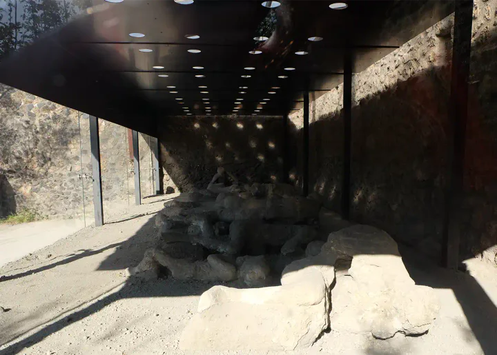 A glass-walled structure with body casts inside