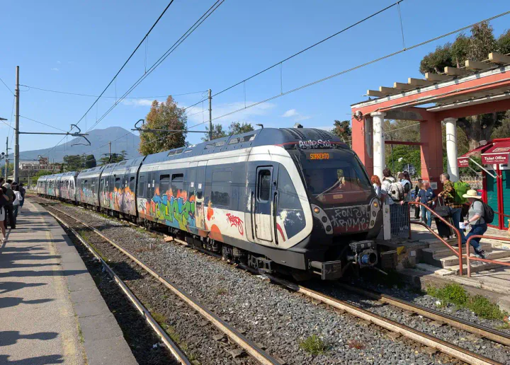 A train from Naples to Sorrento arriving at Pompei Scavi – Villa Dei Misteri station