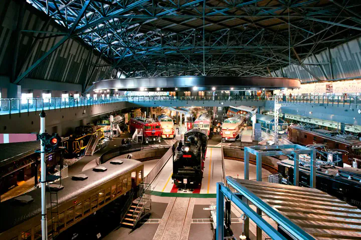 A railway museum with historic locomotives around a central turntable