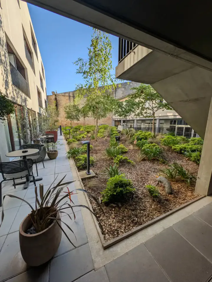 A courtyard garden with hotel rooms leading off it