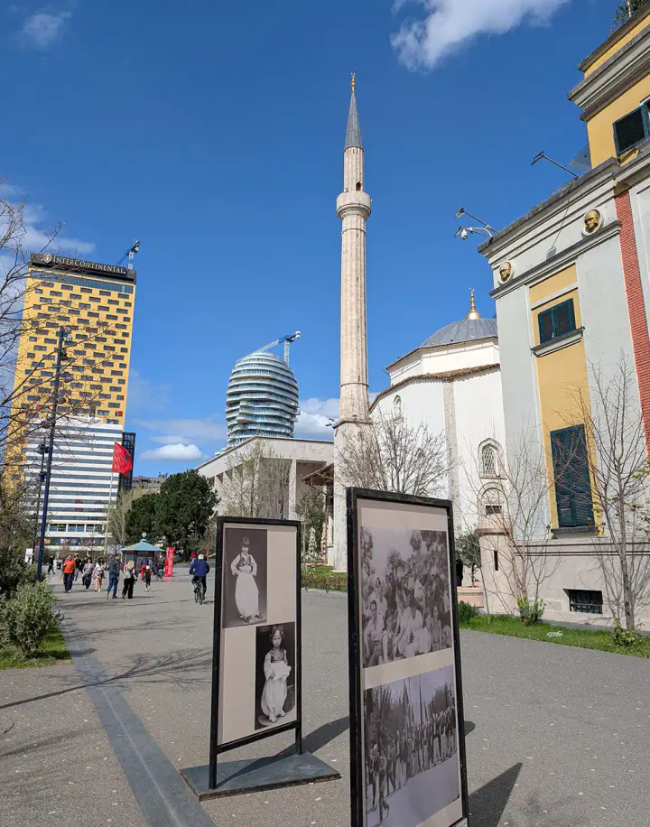 A view of the varied buildings around Tirana's Skanderbeg Square; a Communist-era hotel, a brand new skyscraper in the shape of a man's head, an 18th-century mosque and a 1920s government building