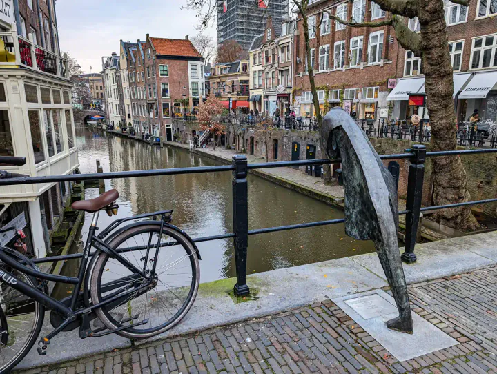 A canal view in the centre of Utrecht, one of the best day trips from Amsterdam. The canal is at a lower level and there are old warehouses.