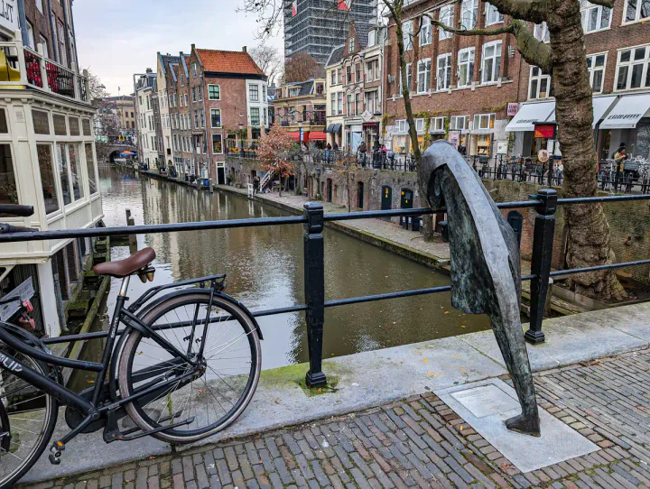 A canal view in the centre of Utrecht, one of the best day trips from Amsterdam. The canal is at a lower level and there are old warehouses.