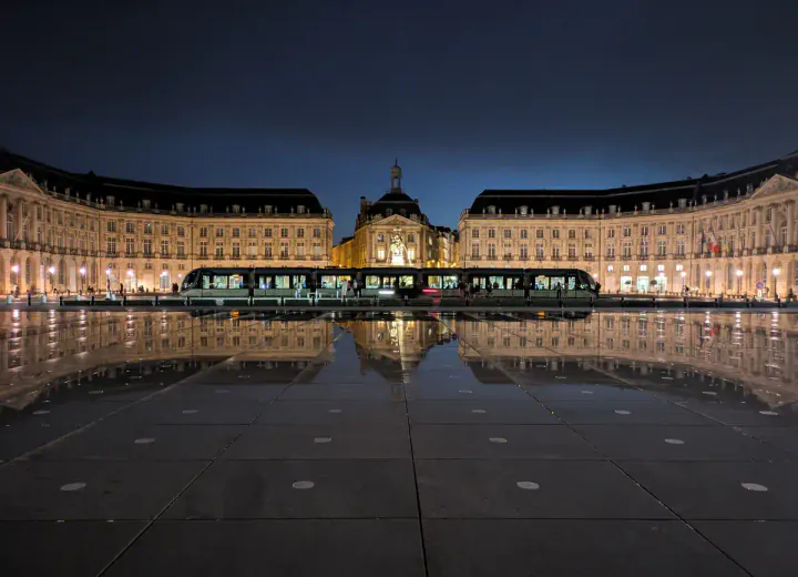 A grand, symmetrical square. The buildings are reflected in the Miroir d'Eau, a shallow pool in front of the square. The Place de la Bourse and Miroir d'Eau are two of the top places to see in Bordeaux