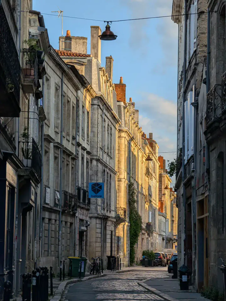 A street in Bordeaux in the early evening, with golden hour light peeking through