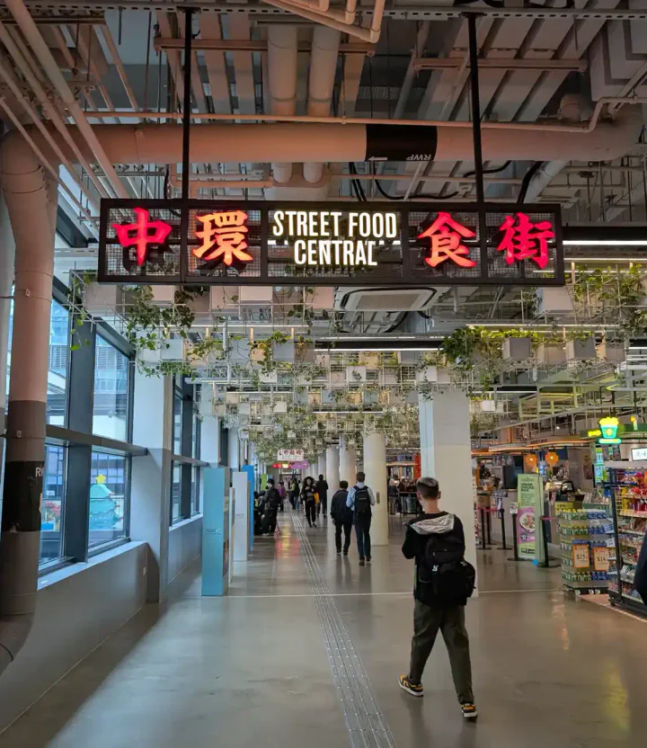 People walking through a building underneath a sign that says "Street Food Central"