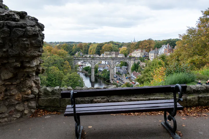A bench in Knaresborough Castle grounds overlooking a beautiful view of the viaduct and river