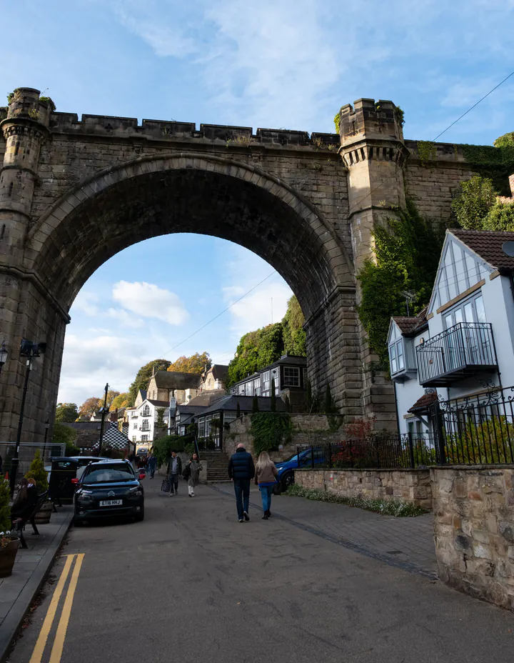 A narrow road underneath the viaduct in Knaresborough, with the arch crossing the road