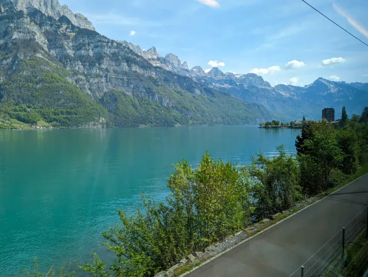 A view of a beautiful blue-green lake taken from a train
