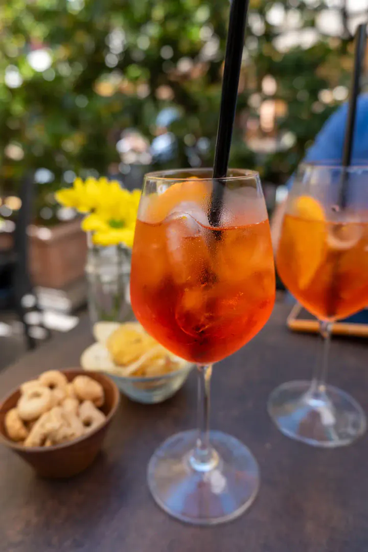 Two glasses of Aperol spritz with aperitivo snacks