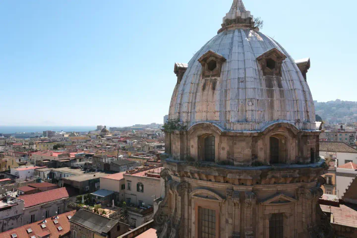 An ornate dome with a view across Naples towards the sea and Capri. The photo was taken during my Naples Cathedral rooftop tour in April 2026.