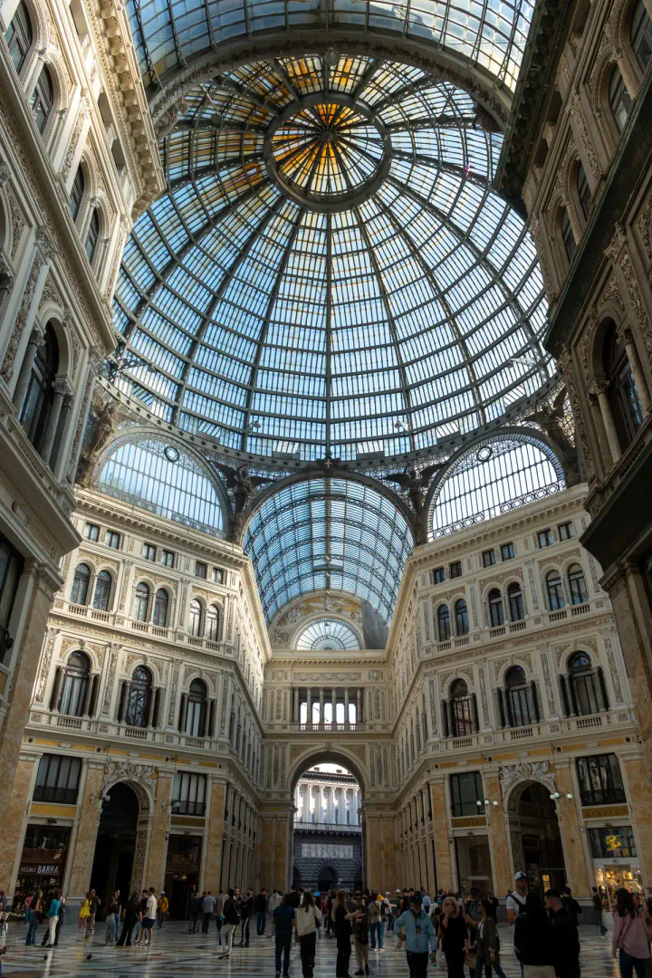 Inside a grand, historic shopping centre with a glazed, domed roof
