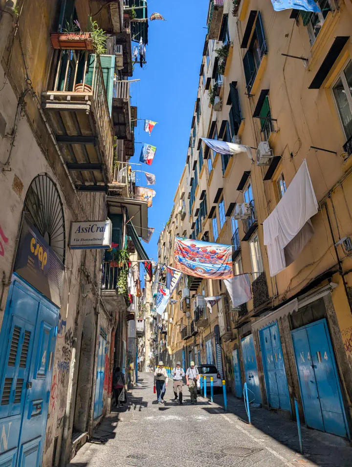 A street in the historic centre with washing and banners hung between tall buildings