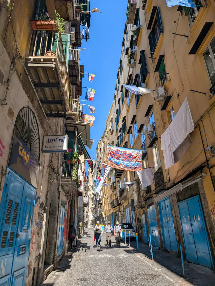 A street in the historic centre with washing and banners hung between tall buildings