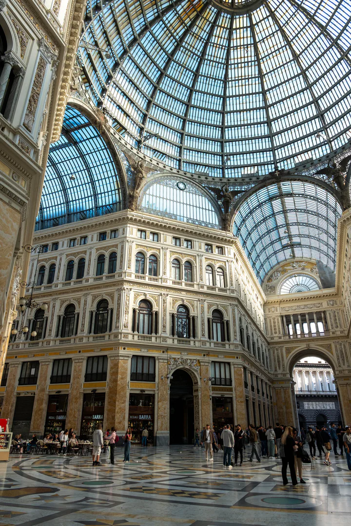 A very grand building with a glass roof and a floor decorated with mosaics