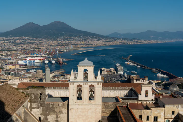 A view across Naples from Castel Sant'Elmo. There are ships in the port and Mount Vesuvius in the background.