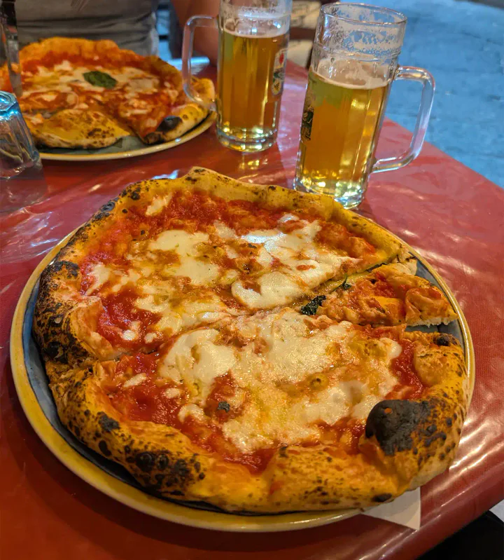 Two pizza Margheritas on plates on a table
