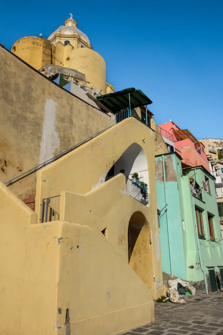 Colourful yellow, pink and mint houses with a yellow church above