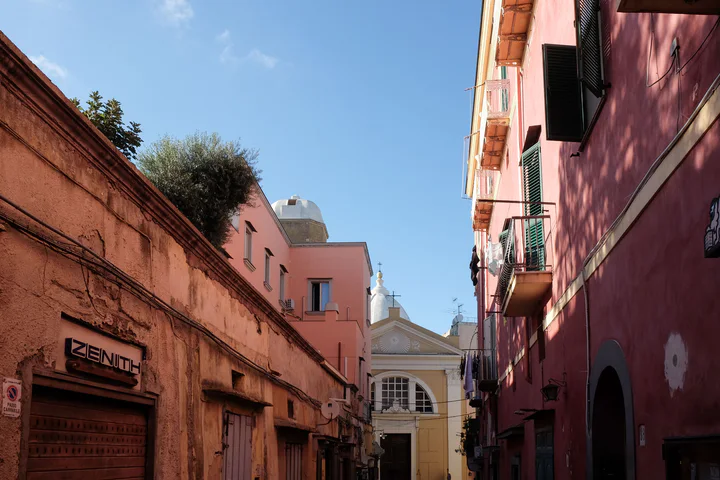 A charming street with pink houses and a yellow church