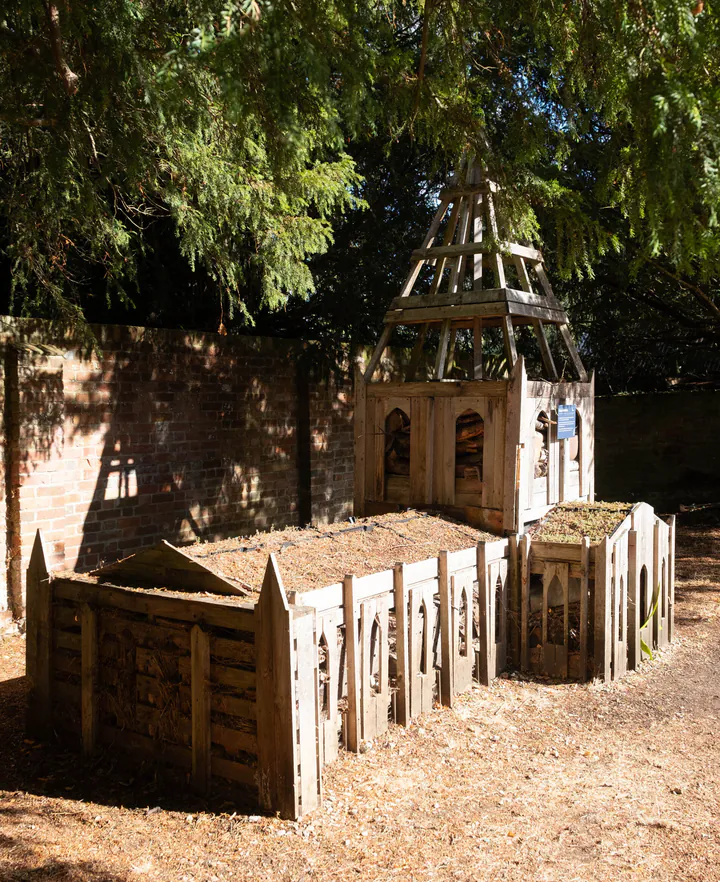 A cathedral-shaped bug hotel made out of wood
