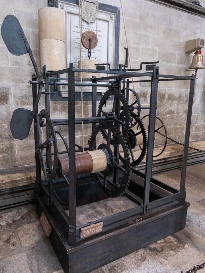 A black iron clock with lots of machinery but no clock face