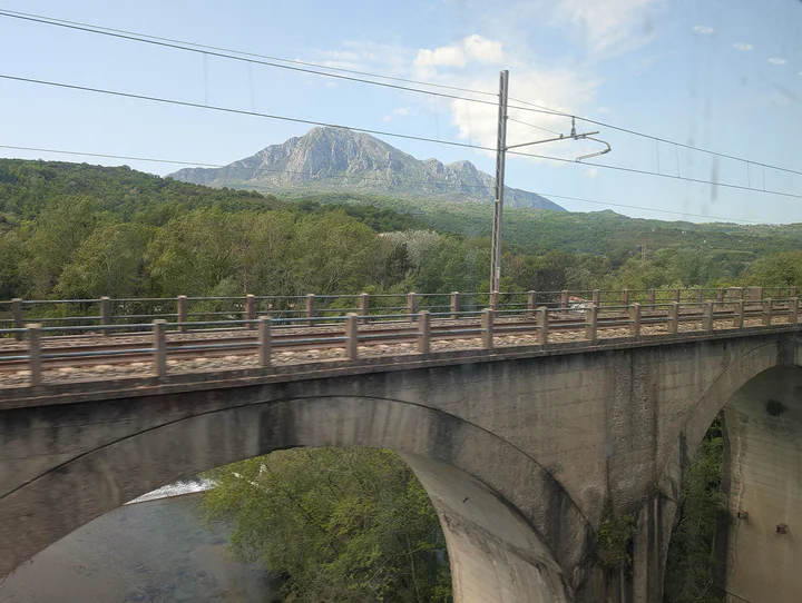 A railway bridge with mountains in the background