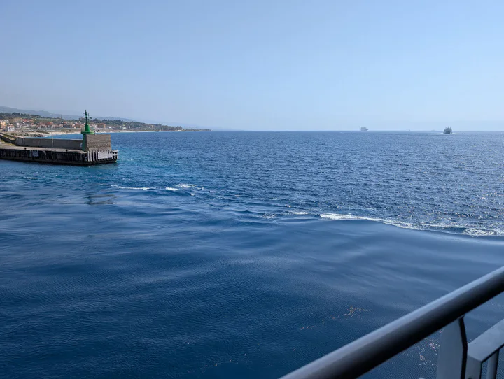 A view from a ship leaving a calm harbour