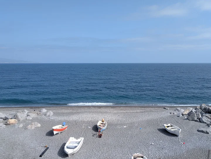 A beach with little boats