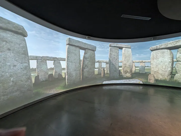 A large 360 degree screen showing the building of Stonehenge