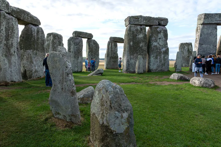 A group of people on a tour inside the inner stone circle at Stonehenge