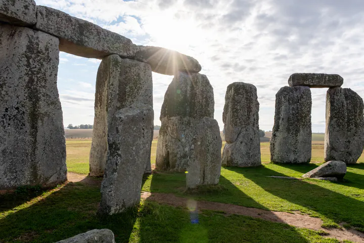 The inner circle of Stonehenge, looking out. It's early in the morning and the sun is low in the sky.