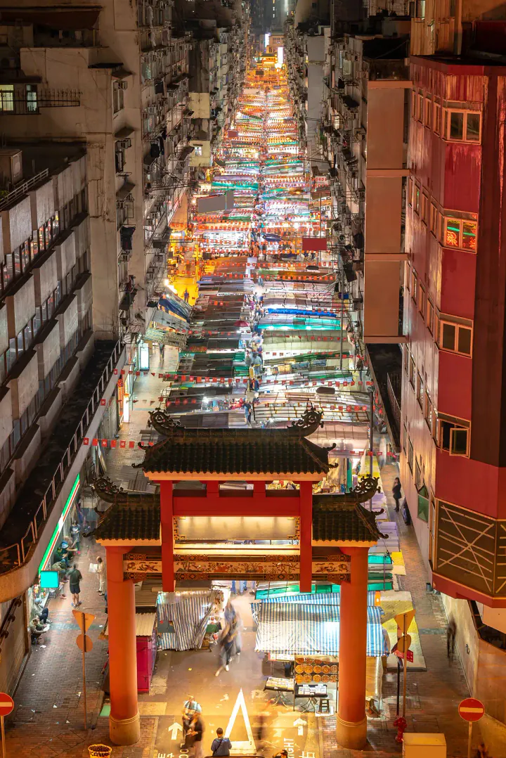 A long straight street filled with market stalls